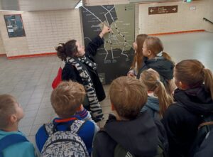 Eine Gruppe von Jugendlichen betrachtet eine Karte von Ost- und Westberlin.